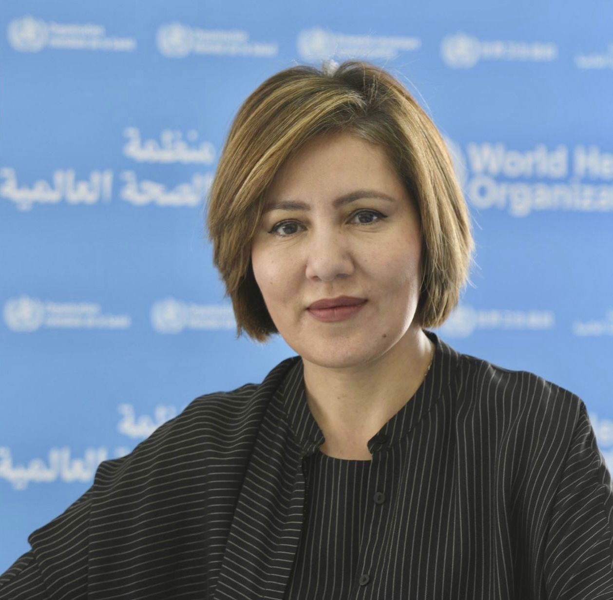 Dr Akjemal Magtymova in front of the World Health Organization backdrop
